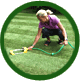 Woman placing water sprinkler on lawn